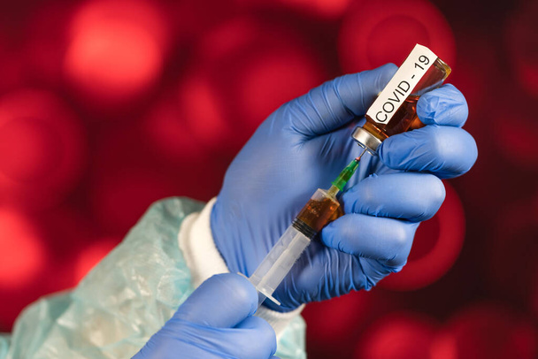 A blue-gloved medical worker draws an ampoule into a syringe. Medical vaccination against coronavirus flu concept. injection bottle for medical glass vials. COVID pandemic - Fotó, kép