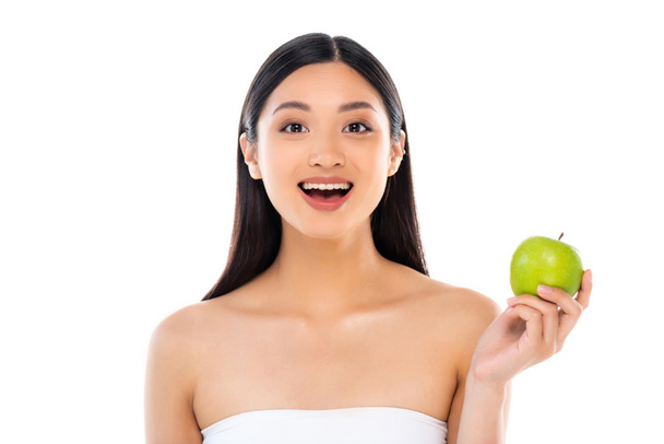 Aufgeregt junge asiatische Frau schaut in die Kamera und hält Apfel isoliert auf weiß - Foto, Bild