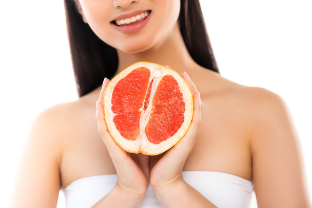 cropped view of woman holding half of juicy grapefruit isolated on white - Фото, изображение