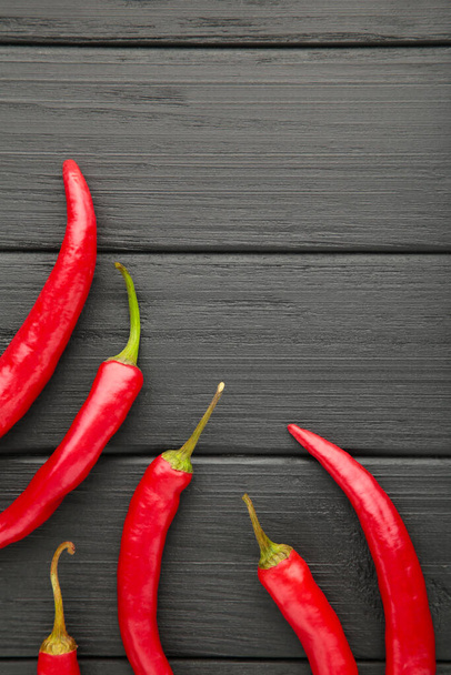 Red Hot chili peppers on black wooden background, closeup. Top view. Vertical - Photo, image