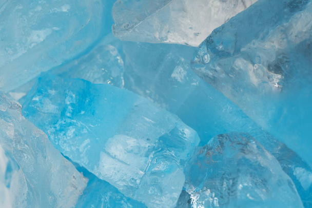 砕いた青い氷のガラスの破片が背景のテクスチャをクラックする。閉じ込められた凍った水 - 写真・画像