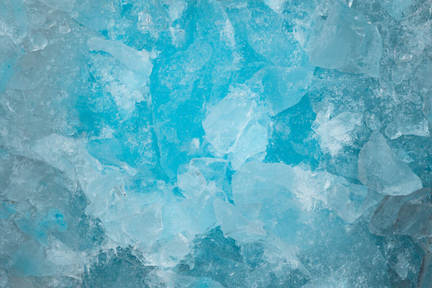Kousky rozdrceného modrého ledového skla praskají na pozadí textury. zblízka zmrazená voda - Fotografie, Obrázek
