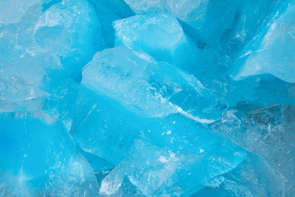 Stukken verbrijzeld blauw ijsglas scheurt de achtergrond textuur. close-up bevroren water - Foto, afbeelding