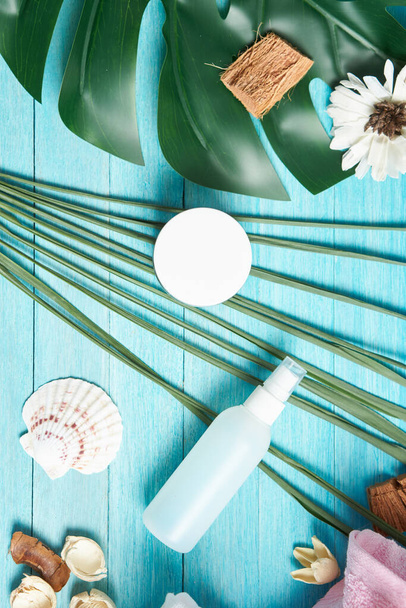 Αξεσουάρ μπάνιου σαπούνι καλλυντικά πράσινα φύλλα μπλε ξύλινο φόντο - Φωτογραφία, εικόνα