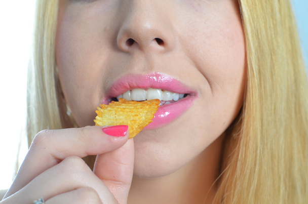 Молодая женщина ест чипсы
 - Фото, изображение