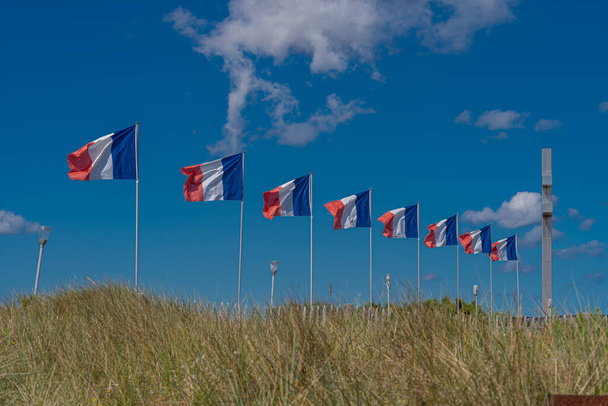 Courseulles-Sur-Mer, França - 08 04 2020: Cruz da Lorena e bandeiras ao longo da praia de Juno - Foto, Imagem