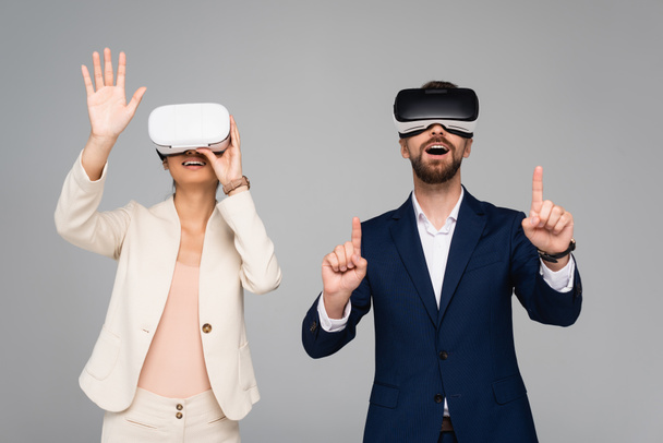 excited business partners in vr headsets gesturing like touching something isolated on grey - Φωτογραφία, εικόνα
