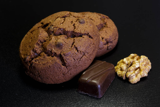 Chocolate cookies. Chocolate pieces on dark background. - Photo, Image