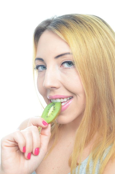 Young woman with fresh kiwi fruit - 写真・画像