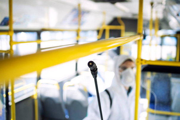 感染性の高いコロナウイルスやCOVID-19の拡散を停止するための公共バス輸送の旅客取扱店の消毒. - 写真・画像