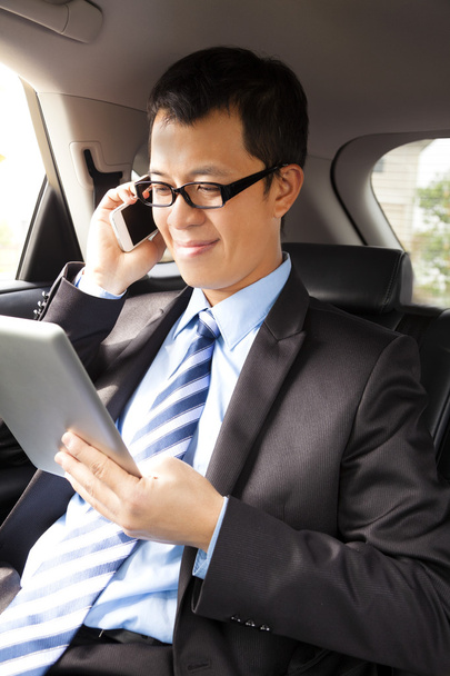 zakenman werken met Tablet PC- en slimme telefoon in de auto - Foto, afbeelding