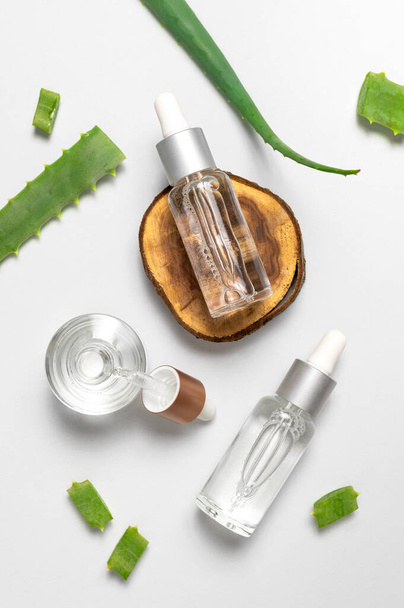 Natural cosmetics concept. Cosmetic oil, serum, gel with aloe vera extract in glass container with pipette on gray background. Organic cosmetics. Top view flat lay. Cosmetics SPA branding mock-up. - Photo, Image
