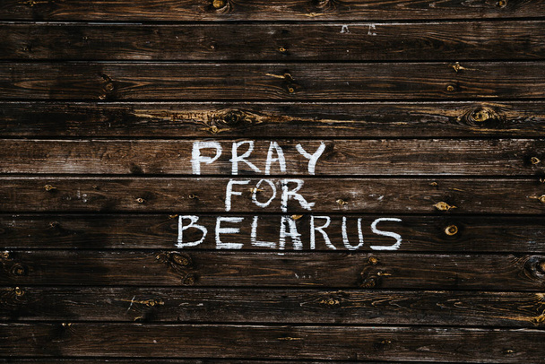Pregate per la nota della Bielorussia. Lettere in gesso su sfondo di legno. Notizie sulla Bielorussia. Protesta pacifica e sciopero a Minsk. - Foto, immagini