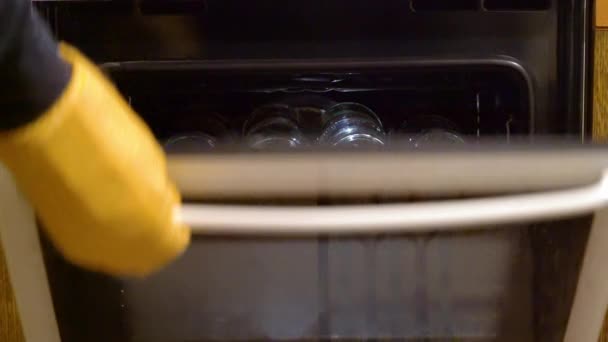 Βγάζοντας τα αποστειρωμένα γυάλινα βάζα από το φούρνο για μαρμελάδα - Πλάνα, βίντεο