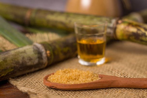 Cachaca ist der Name eines typischen alkoholischen Getränks, das in Brasilien aus Zuckerrohr hergestellt wird. Traditionelles Getränk aus Brasilien auf Holztisch. - Foto, Bild