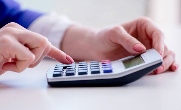 Hands working on accounting calculator calculating profit - Photo, Image