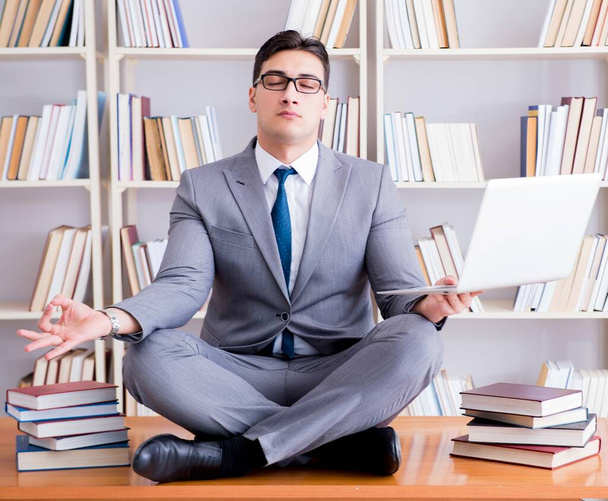 Бизнесмен студент в позе лотоса медитирует с ноутбуком я - Фото, изображение