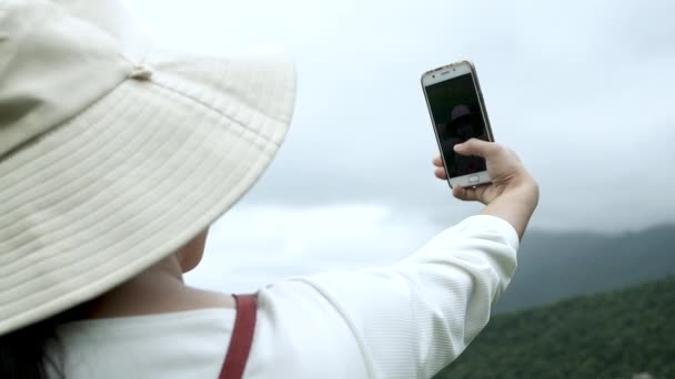 Турист насолоджується природою і фотографує зі смартфоном на гірському тлі
. - Кадри, відео