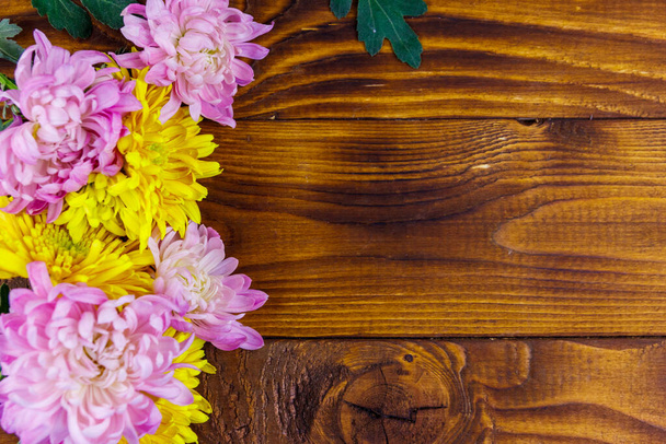 Beautiful chrysanthemums on wooden background. Top view, copy space - Φωτογραφία, εικόνα