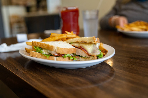Курячий бекон тане бутерброд з картоплею на тарілці в ресторані. Інтенсивно сфотографовані з малою глибиною різкості для художнього ефекту
 - Фото, зображення