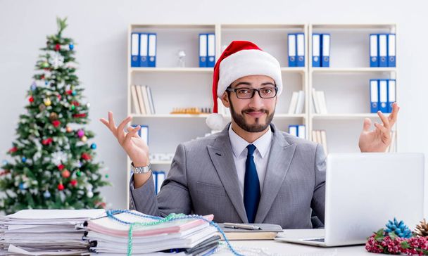 Young businessman celebrating christmas in the office - Foto, Imagen