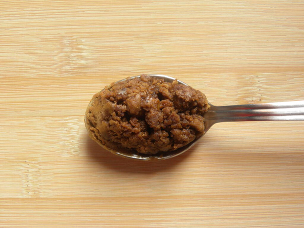 Brązowy kolor Granulki z trzciny cukrowej na łyżce ze stali nierdzewnej - Zdjęcie, obraz