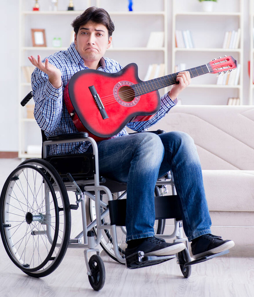 家でギターを弾く障害者 - 写真・画像