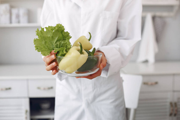 Doctor in a kitchen with a vegetables - Photo, Image