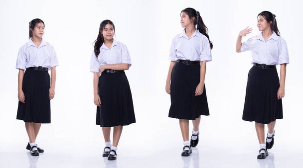 Full length profile shot της έφηβης ασιάτισσας με στολή μαθητή λευκό πουκάμισο μαύρα παπούτσια φούστα, τα πόδια προς τα εμπρός κατεύθυνση. Studio φωτισμού λευκό φόντο isolatd - Φωτογραφία, εικόνα