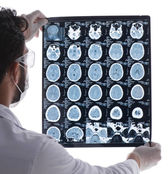 Médico joven mirando imágenes de rayos X aisladas en blanco - Foto, Imagen