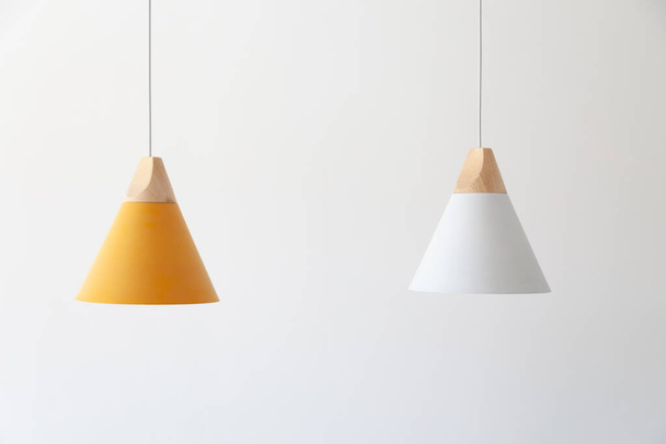 Lámparas blancas y amarillas con piezas de madera ligeras cuelgan de los cables - Foto, Imagen