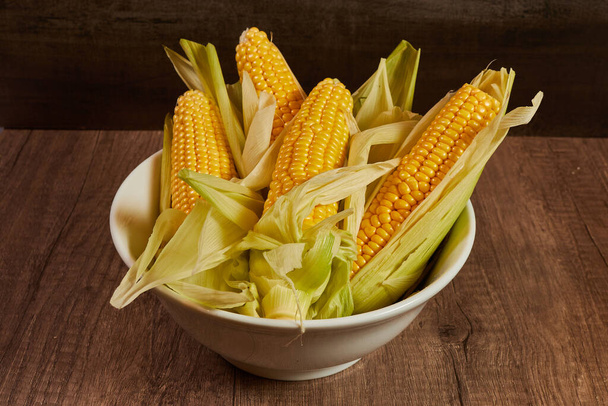Čerstvá kukuřice na klobáse v bílé misce na stole - Fotografie, Obrázek
