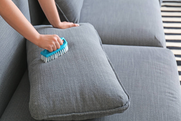 Mujer quitando la suciedad del sofá en casa - Foto, Imagen