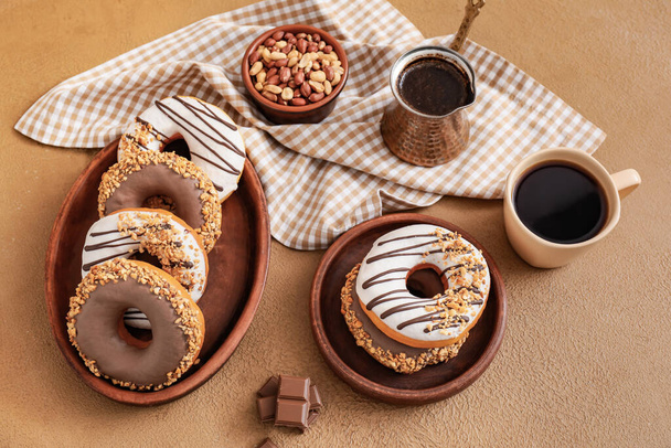 Samenstelling met lekkere donuts en koffie op tafel - Foto, afbeelding