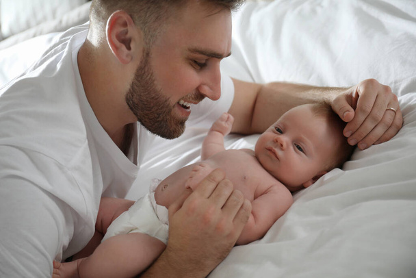 Father with his newborn son on bed - Foto, Bild