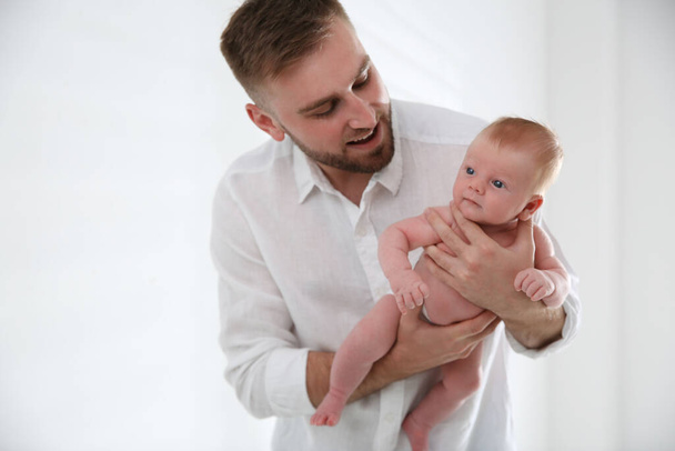 Father with his newborn son on light background - Valokuva, kuva