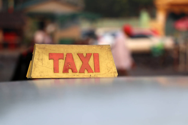 Taxi luce segno o taxi segno in colore giallo cupo con testo rosso sul tetto dell'auto sulla strada sfondo sfocato, Myanmar. - Foto, immagini