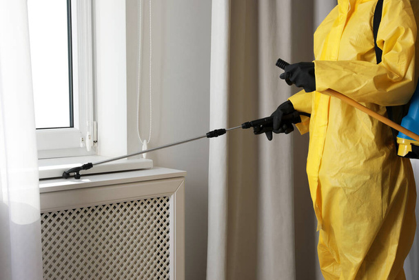 Pest control worker spraying pesticide on window sill indoors, closeup - Zdjęcie, obraz