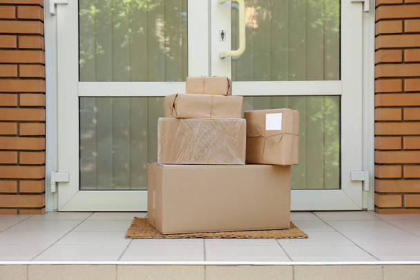 Delivered parcels on door mat near entrance - Fotó, kép