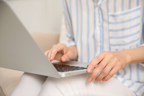 Young woman with laptop sitting indoors, closeup - Zdjęcie, obraz
