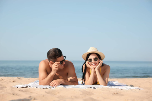 Happy couple resting on sunny beach at resort - Fotoğraf, Görsel