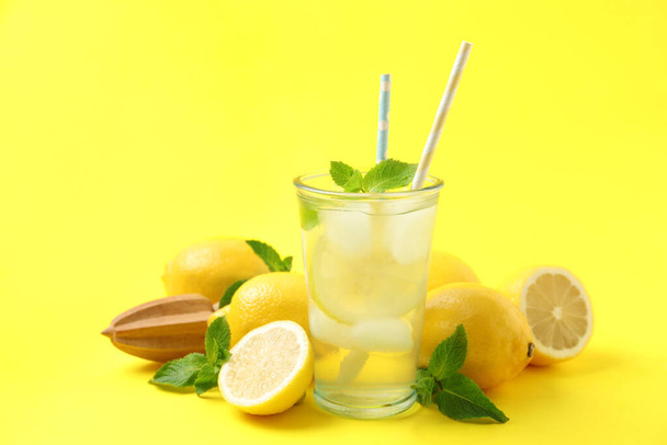 Natural freshly made lemonade with squeezer on yellow background. Summer refreshing drink - Foto, Bild