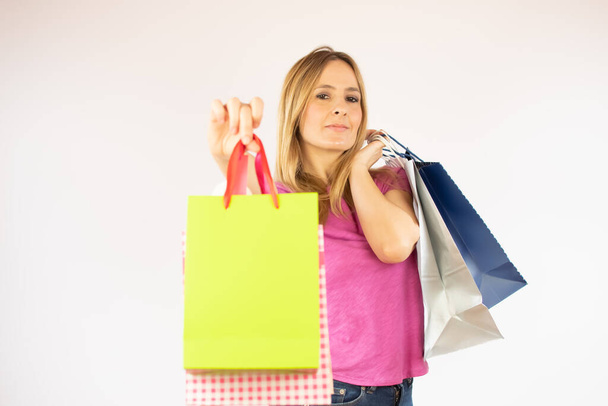 Красива покупка жінки в рожевій сорочці з сумками в руці
 - Фото, зображення