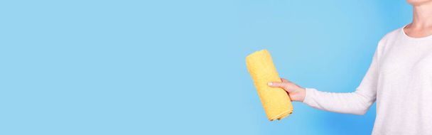 Hand with folded yellow towel. - Foto, Bild