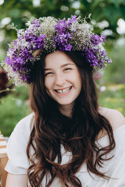 portrait of a pretty young girl dressed in a long linen dress posing for a photo among flowers at a home mini flower farm - Valokuva, kuva