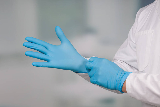 Primer plano de las manos poniéndose guantes médicos  - Foto, Imagen
