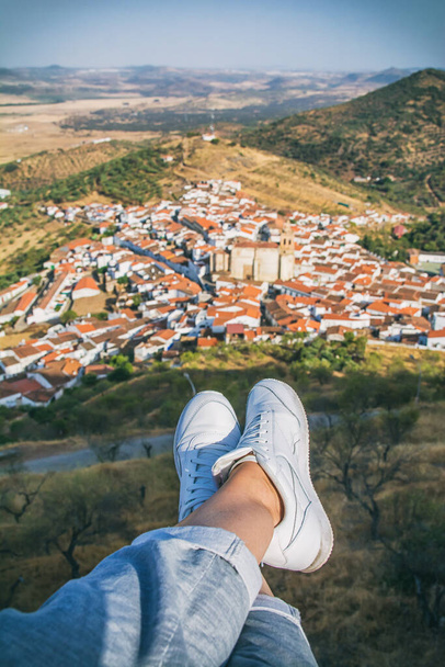 Nierozpoznawalny turysta, spoglądający na piękne widoki na wieś położoną w dolinie otoczonej naturą.Turysta relaksujący się z widokiem na miasto w Estremadurze, Hiszpania. - Zdjęcie, obraz
