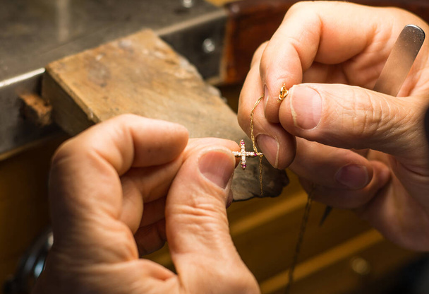 Mains d'un artisan bijoutier travaillant sur des bijoux. Orfèvrerie Bijoux d'atelier et articles de valeur - Photo, image