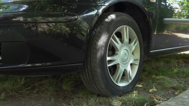 Un mécanicien de voiture dans la boîte de garage serre les contrôles à l'aide d'une clé à chocs pour serrer l'écrou de pneu de voiture - Séquence, vidéo