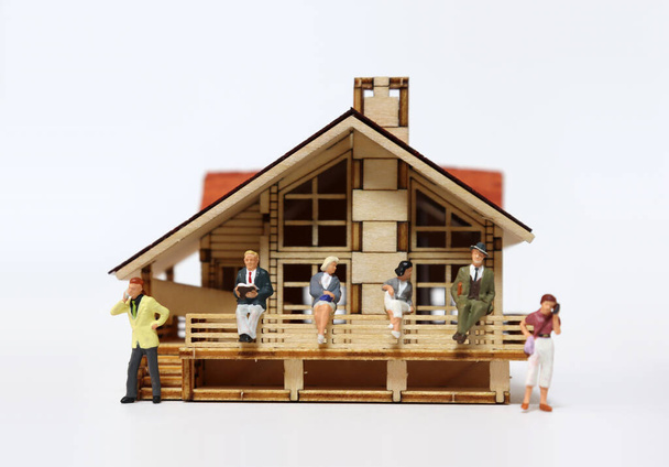 Die Konzepte von Stay at Home. Miniaturmenschen und Miniaturhaus. - Foto, Bild